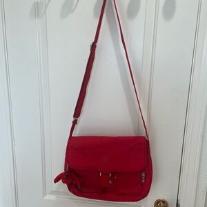 Gently used red Kipling crossbody bag.